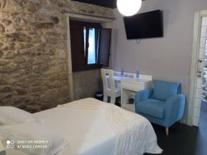 - une chambre avec un lit, une chaise et un bureau dans l'établissement Casa O Gures, à Serantes