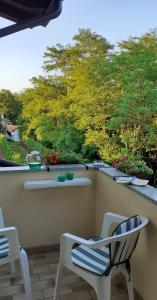 a balcony with two chairs and a view of trees at B&B Ca di me in Premariacco