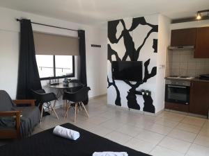 a living room with a tv and a kitchen at St Lazaros, Larnaca Center Studio in Scala