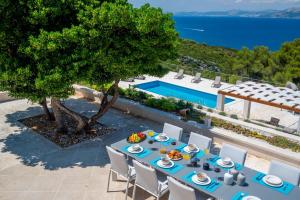 een tafel met eten en uitzicht op het water bij Luxury Villa Castello di Pietra with private pool in Pučišća