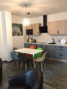 バラトンレッレにあるLIDO nappali + 3 háló apartmanのキッチン(テーブル、椅子付)