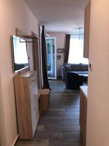 バラトンレッレにあるLIDO nappali + 3 háló apartmanのリビングルーム(テレビとソファ付)の廊下