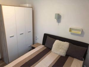 バラトンレッレにあるLIDO nappali + 3 háló apartmanのベッドルーム1室(ベッド1台、白いキャビネット付) +11枚の写真