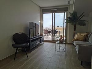 a living room with a tv and a couch and a chair at Greenhills La Zenia luxe penthouse 5 pers Orihuela in Los Dolses