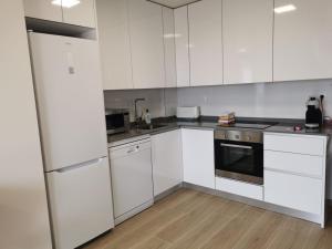 a white kitchen with white cabinets and appliances at Greenhills La Zenia luxe penthouse 5 pers Orihuela in Los Dolses