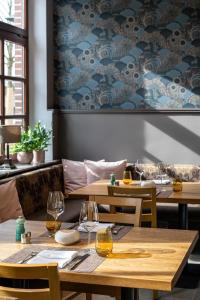 a dining room with two tables and two wine glasses at LandHaus Zum LindenHof in Marxen