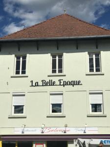 un bâtiment blanc avec un panneau sur son côté dans l'établissement La belle Epoque, à Damparis