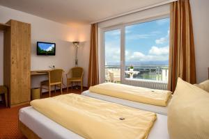 a hotel room with two beds and a window at JUFA Hotel Schwarzwald in Lenzkirch