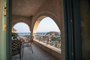 balcón con mesa, sillas y vistas al océano en Elysium Living Parga, en Parga