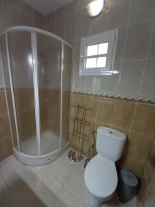 a bathroom with a shower and a toilet and a window at GARABATO in La Pared