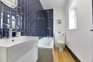 a white bathroom with a sink and a toilet at Host & Stay - Blacksmith's Cottage in Amble