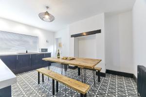 a kitchen with a table and benches in a room at Host & Stay - Blacksmith's Cottage in Amble