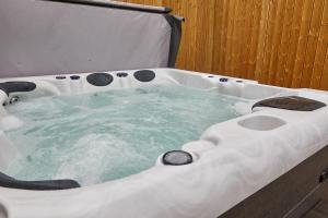 a bath tub filled with water in a bathroom at Host & Stay - Blacksmith's Cottage in Amble