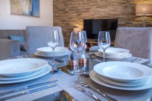 a table with plates and wine glasses on it at Mansio Suites Basinghall in Leeds