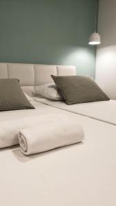 two beds with white sheets and pillows on them at Fiorino Rooms Korčula in Korčula