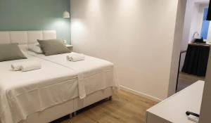 1 dormitorio con 1 cama blanca y 2 almohadas en Fiorino Rooms Korčula, en Korčula