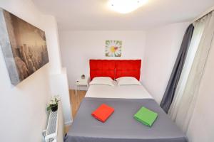 a bedroom with a bed with two colorful pillows on it at Bucharest Nightlife Apartments in Bucharest