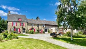 a large stone house with red shutters and a yard at Greener Pastures - Normandy Self Catering Gites in La Chapelle-Engerbold