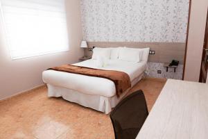 Habitación de hotel con cama grande y ventana en Hotel Ancora Urban Center en Finisterre