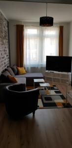 - un salon avec un canapé et une télévision dans l'établissement Joanna Apartment - MA Rheinau 2, à Mannheim