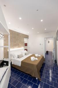 - une chambre avec un grand lit revêtu de carrelage bleu dans l'établissement Anreale Rooms Paestum, à Paestum
