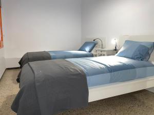 een slaapkamer met 2 bedden en blauwe kussens bij Apartment Costa Brava en Verges in Verges