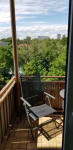 einen Stuhl auf einem Balkon mit Blick auf die Bäume in der Unterkunft Joanna Apartment - MA Rheinau 2 in Mannheim