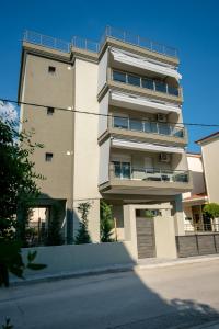 a tall white building with a balcony at OLIVE 102 in Perea