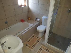La salle de bains est pourvue de toilettes, d'une douche et d'un lavabo. dans l'établissement Natures Cabin, à Hibberdene