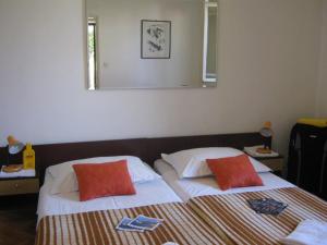 een slaapkamer met twee bedden en een spiegel aan de muur bij Apartments and Rooms Artemida in Dubrovnik