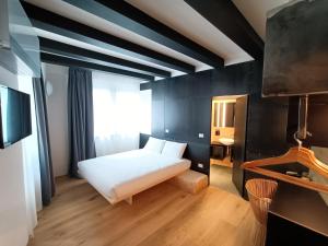a bedroom with a white bed and a black wall at Le Meridiane Luxury Rooms In Trento in Trento