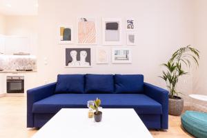 Sofá azul en la sala de estar con mesa en Casa Moderna -Two Bedroom Apartment en Corfú