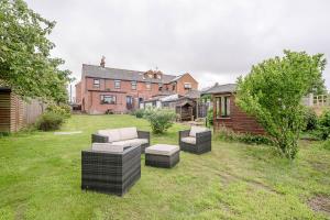 a yard with a group of chairs and a house at Hillside View in Southwold