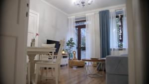 een witte woonkamer met een tafel en een bureau bij ApartSea 2 Gdynia in Gdynia