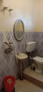 W łazience znajduje się toaleta, umywalka i lustro. w obiekcie Hotel The Kings w mieście Kota