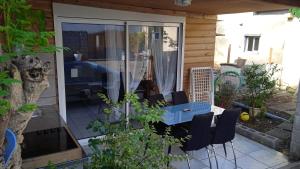 eine Terrasse mit einem Tisch und Stühlen sowie einer Glasschiebetür in der Unterkunft Chez Fred A Saint Andre in Saint-André