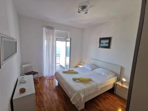 a bedroom with a bed with two yellow towels on it at Apartments Lucic in Senj