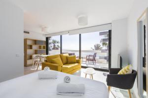 a living room with a yellow couch and a table at Seafront Boutique CalaBeach Rincón de la Victoria in Cala del Moral