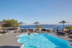 uma pessoa está a mergulhar numa piscina em Mr and Mrs White Oia - Santorini em Oia