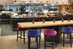 聖保羅的住宿－Domaine du Mas De Pierre，厨房配有紫色和紫色的吧台凳