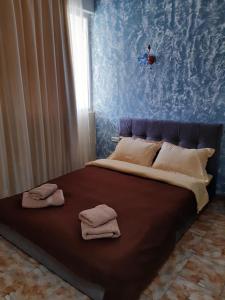 Una cama con toallas en un dormitorio en Морская жемчужина en Odesa