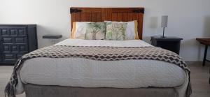a bedroom with a large bed with a wooden headboard at Pipo People House in Óbidos