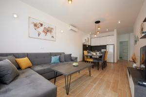 a living room with a gray couch and a table at Apartments Antica Trogir in Trogir