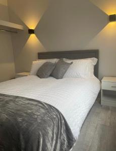 ein Schlafzimmer mit einem großen Bett mit weißer Bettwäsche und Kissen in der Unterkunft Apt 3, Lisvarna House in Buncrana