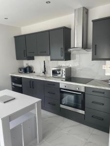a kitchen with gray cabinets and a white counter top at Apt 3, Lisvarna House in Buncrana