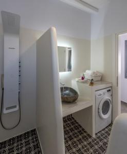 a bathroom with a sink and a washing machine at Zeus Suite in Triovasálos