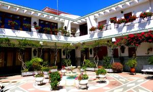 une cour d'un bâtiment avec des plantes en pot dans l'établissement Estudio con encanto en la Carihuela, à Torremolinos