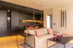 a living room with a white couch and a kitchen at Valencia Luxury - Sea Port II in Valencia