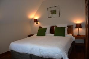 Un dormitorio con una gran cama blanca con almohadas verdes. en Val Lachard, en Villard-de-Lans