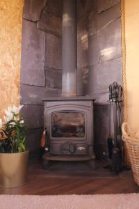 a stove in a room with a stone wall at The Cabin Project in Portglenone